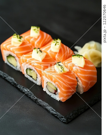 Fresh salmon sushi rolls with avocado and pineapple on black slate plate. 122070646