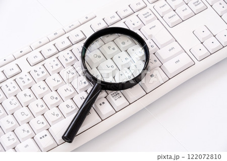 虫眼鏡とパソコンでリサーチや検索イメージ 122072810