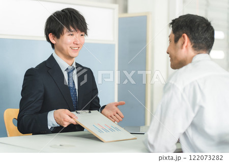 受付・窓口で男性客を接客する若いアジア人ビジネスマン 受付・窓口で男性客を接客する若いアジア人ビジネスマン 122073282