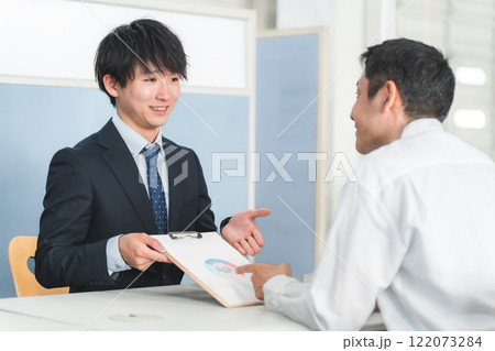 受付・窓口で男性客を接客する若いアジア人ビジネスマン 122073284