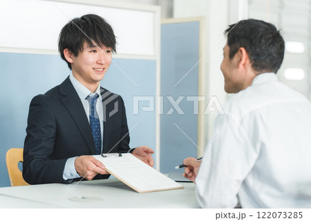 受付・窓口で男性客を接客する若いアジア人ビジネスマン 受付・窓口で男性客を接客する若いアジア人ビジネスマン 122073285