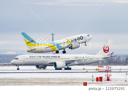 冬の新千歳空港　雪煙と離陸する飛行機　北海道千歳市　 122075291