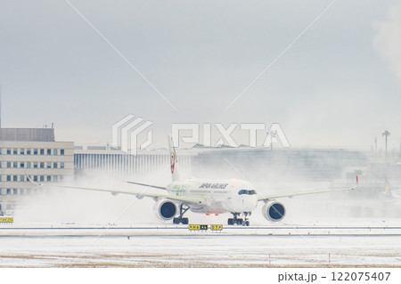 冬の新千歳空港　雪煙とタキシング中の飛行機　北海道千歳市　 122075407