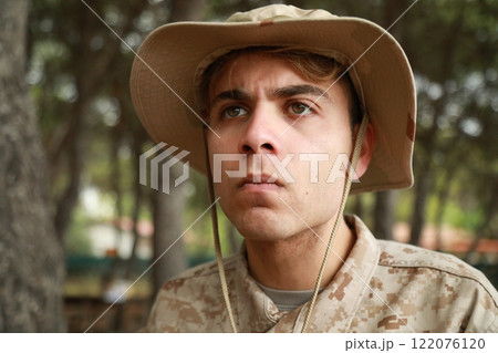 Young Military Man Hides From The Enemy Behind A Log In The Forest In War Terror Young Military Man Hides From The Enemy Behind A Log In The Forest In War Terror 122076120