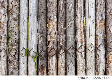 Old grungy dark wooden fence made of slab boards 122076142