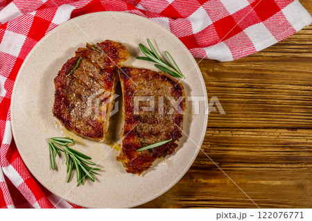 Grilled pork steaks with rosemary on wooden table. Top view 122076771