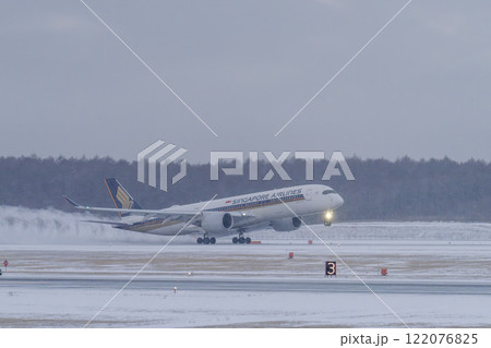 冬の新千歳空港　雪煙と着陸する飛行機　北海道千歳市　 122076825
