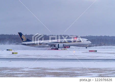 冬の新千歳空港　雪煙と着陸する飛行機　北海道千歳市　 122076826