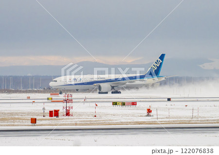 冬の新千歳空港　雪煙とタキシング中の飛行機　北海道千歳市　 122076838