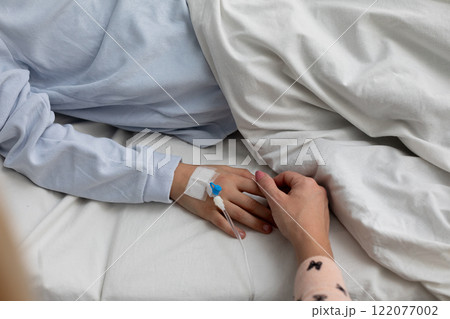 Tender Moment Holding Hands in a Hospital Setting to Offer Comfort and Emotional Support 122077002