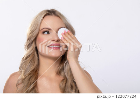 Woman Applying Skincare with a Cotton Pad for Daily Care and Nurturing Her Skin Routine 122077224