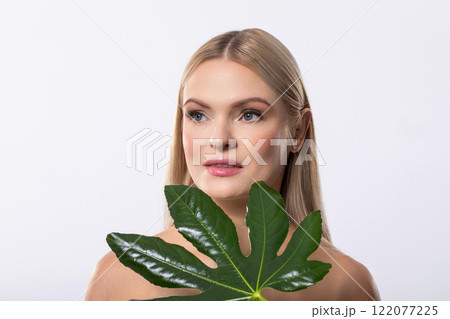 This is a captivating portrait of a Woman holding a Leaf set against a pristine White Background This is a captivating portrait of a Woman holding a Leaf set against a pristine White Background 122077225