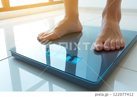 Woman Weighing Herself and Measuring Weight on Modern Digital Scale in Sunny Room 122077412