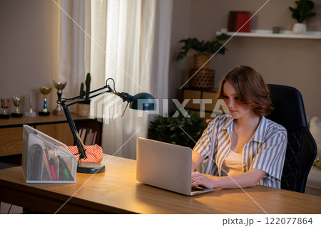 A Focused Professional Effectively Working from Their Home Office with a Laptop Computer 122077864