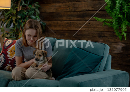 Savoring a Delightful and Cozy Moment Together with an Adorable Puppy on a Very Comfortable Couch Savoring a Delightful and Cozy Moment Together with an Adorable Puppy on a Very Comfortable Couch 122077905