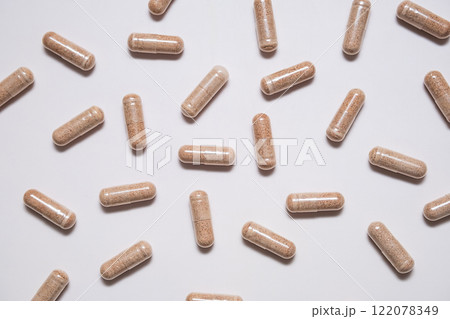 Capsules of dietary supplement are scattered on beige background. 122078349