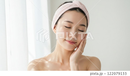 自然光の中で顔に手を添える女性 122079133