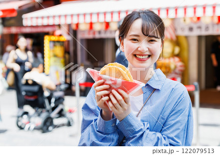 大阪道頓堀で名物のたこせんを食べる女性 122079513