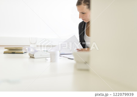 View around a partition of a woman in an office View around a partition of a woman in an office 122079939