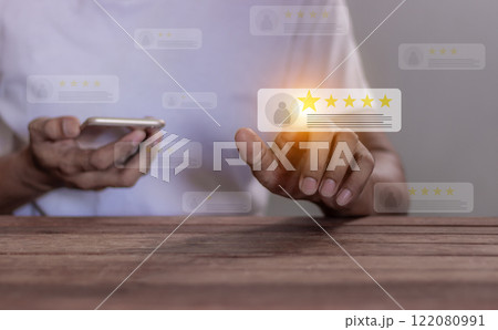 Young Man using smartphone hand touching five star to review and give 5 stars with very good results 122080991