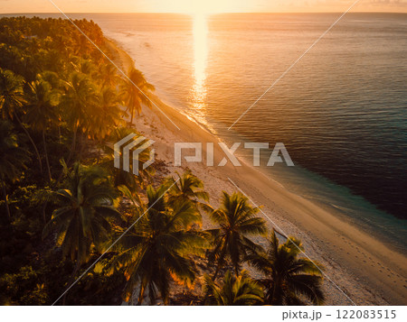 Warm sunset on Maldives tropical beach with palms trees and ocean. Above view Warm sunset on Maldives tropical beach with palms trees and ocean. Above view 122083515