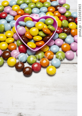 ハート型の入れ物とカラフルな粒チョコレート 122083903