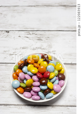 丸形の小皿に入ったカラフルな粒チョコレート 丸形の小皿に入ったカラフルな粒チョコレート 122083913