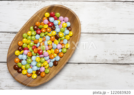 木皿の上に乗ったカラフルな粒チョコレート 122083920