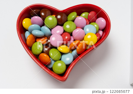 真っ赤なハート型のココット皿と粒チョコレート 122085077