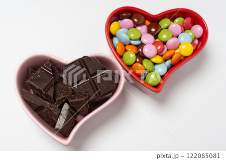 ハート型のココット皿と粒チョコレートと割れた板チョコレート ハート型のココット皿と粒チョコレートと割れた板チョコレート 122085081