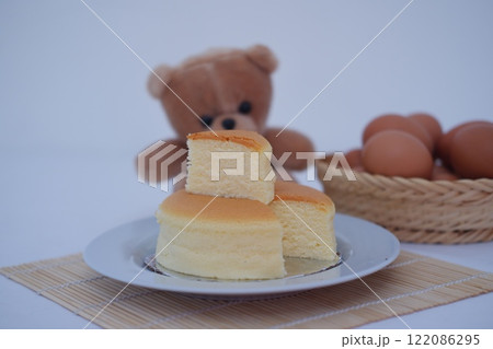 Cheesecake on white plate and eggs on bamboo mat Cheesecake on white plate and eggs on bamboo mat 122086295