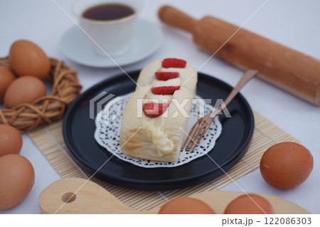 Strawberry cheese cake with eggs in basket on a table. 122086303