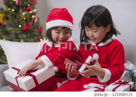 サンタ衣装の姉妹がクリスマスプレゼントを開ける瞬間 122086515