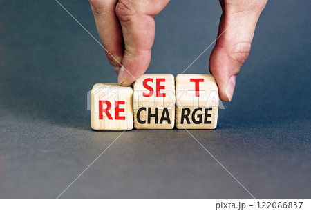 Reset and recharge symbol. Concept words Reset Recharge on beautiful wooden block. Beautiful grey table grey background. Businessman hand. Business reset and recharge concept. Copy space. Reset and recharge symbol. Concept words Reset Recharge on beautiful wooden block. Beautiful grey table grey background. Businessman hand. Business reset and recharge concept. Copy space. 122086837