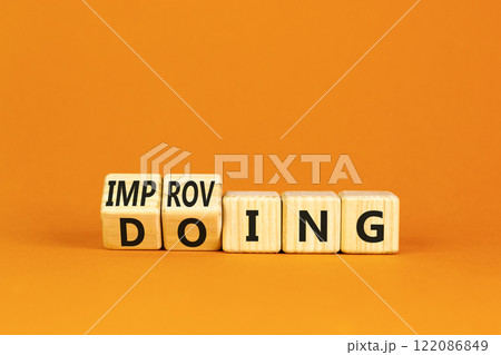 Doing or improving symbol. Turned wooden cubes and changed the word Doing to Improving. Beautiful orange table orange background. Educational business doing or improving concept. Copy space 122086849
