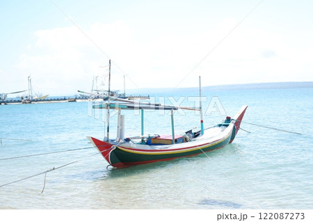 Quiet Beach with Traditional Boat and Clear Blue Waters Quiet Beach with Traditional Boat and Clear Blue Waters 122087273