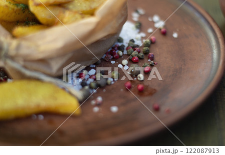 Spices with fried potatoes on a plate 122087913