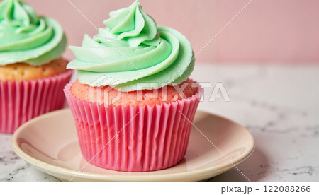 Colorful cupcakes with green frosting create a delightful dessert display in a pastel setting 122088266