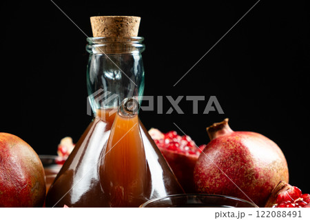 Natural Traditional Pomegranate Vinegar in Vinegar Cruet on Black Background 122088491