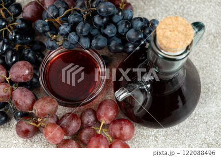 Red wine vinegar in glass vinegar bowls among grapes 122088496