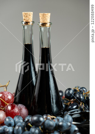 Balsamic vinegar in bottles among grapes 122088499