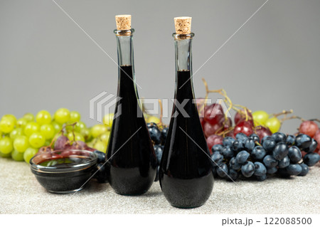 Balsamic vinegar in bottles among grapes 122088500