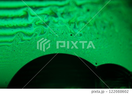 Green liquid surface, fantastic bubbles in the darkness, dark fantastic background, transparent forms, empty space, dark background 122088602