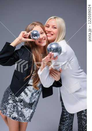 A Stylish and Dazzling Duo Showcasing Disco Balls While Wearing Glamorous Fashionable Outfits 122089024
