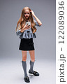 A Trendy Young Girl Dressed in a Fashionable Outfit is Holding a Smartphone in Her Hand 122089036