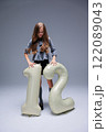 A young girl with an inflatable item sized 12 inches poses during a vibrant fashion photo shoot 122089043
