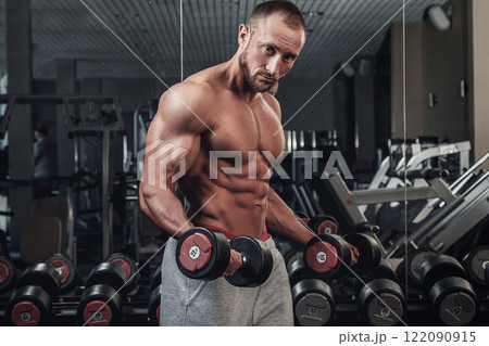 Muscular man doing a exercise for biceps 122090915