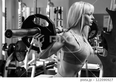 Beautiful woman with barbell on her shoulders Beautiful woman with barbell on her shoulders 122090927