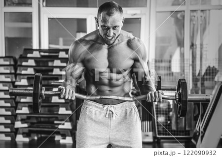 Muscular man during workout in the gym 122090932