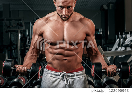 Muscular man doing a exercise for biceps Muscular man doing a exercise for biceps 122090948